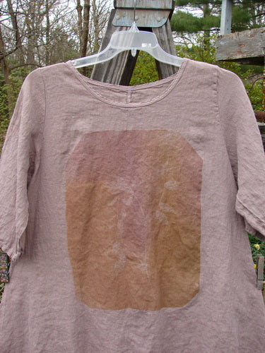 Barclay Linen Lucida Top Whisper Wheat Sprig Mauve Size 0 displayed on a hanger, highlighting its rounded neckline, flowy A-line shape, and almost three-quarter sleeves, showcasing its lightweight linen fabric.