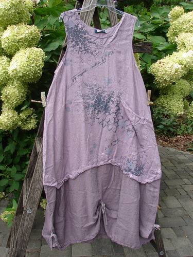 Barclay NWT Linen Explorer Jumper Tiny Botanical Sea Fog Size 0 displayed on a wooden ladder outdoors, featuring an asymmetrical hem, scoop neckline, and handwritten-script print with floral motifs, embodying BlueFishFinder's vintage aesthetic.