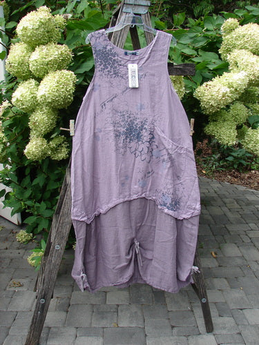 Barclay NWT Linen Explorer Jumper Tiny Botanical Sea Fog Size 0 displayed on a wooden stand, showcasing its sleeveless, scoop-neck top and wide-leg cropped pants, adorned with a subtle floral print.