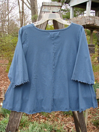 Barclay Three Quarter Sleeved Crop A Lined Tee Play Dress Up Navy Size 0, featuring a rounded neckline and curly edgings, displayed on a wooden rack, showcasing its unique A-line shape and style.