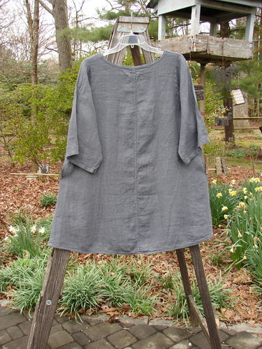 Barclay NWT Linen Lucida Top Fern Fare Steel Blue Diatom Size 0 displayed on a wooden stand, showing its flowy A-line shape, rounded neckline, and almost three-quarter sleeves.