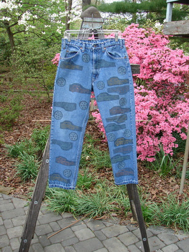 1995 Levi Strauss & Co Denim Blue Jean Travel Dark Stone Wash Size 1, featuring intricate travel-themed designs and signature blue fish patch, displayed in perfect condition from the 1995 Fall Collection.