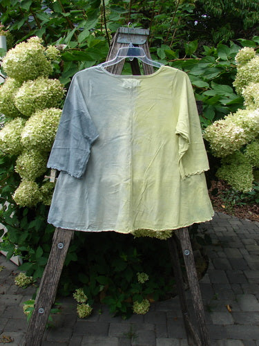 Barclay NWT Three Quarter Sleeved Cafe Tee Free Bird Mottled Violet Citron Size 0, draped on a wooden ladder, showcases a loose, hand-dyed design with a rounded neckline and sweet curly edgings.