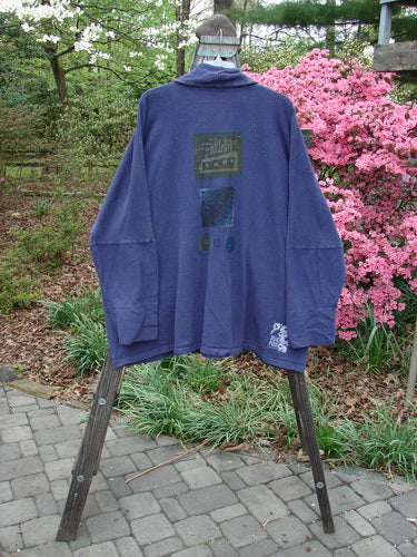 1995 Reprocessed Deco Jacket Jeweled Flower Button Royal Orchid OSFA on a rack, showcasing its dense nubby cotton texture, drop dolman shoulders, deep V neckline, and oversized painted pockets.