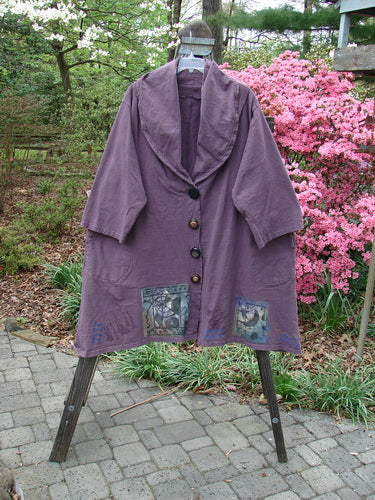 1994 Reprocessed Carriage Jacket Star Moon Fuji Purple Altered OSFA on a rack, featuring oversized vintage buttons, pleated shoulders, billowy collar, deep pockets, and unique hemline.