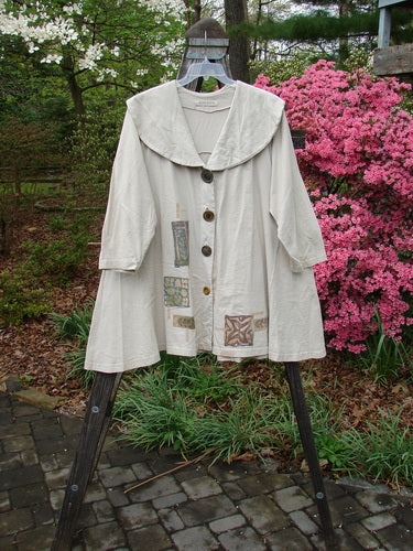 1994 Wanderer's Jacket Mindful Mosaic Mist Altered Size 1 features a wide shawl collar and sectional side inserts for continuous movement, displayed on a rack.