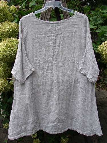 Barclay NWT Linen Zen Pocket Tunic Unpainted Pearl Smoke Size 0 on a hanger, showcasing a wide scooped neckline, three-quarter sleeves, A-line shape, curved waist seam, dual drop pockets, and varying hemline.