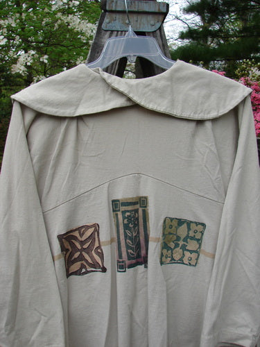 1994 Wanderer's Jacket Mindful Mosaic Mist Altered Size 1 displayed on a hanger, featuring wide shawl collar, stitched folds at shoulders, and sectional side inserts for flair and continuous movement.