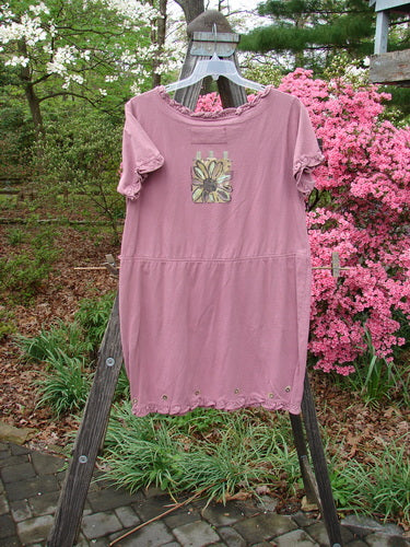 1991 Milkmaid Dress Daisy Dusty Pink OSFA displayed on a wooden stand, featuring a unique lower hip bell shape, drop waistband, curly neck hem, and sleeve line with daisy-themed paint.