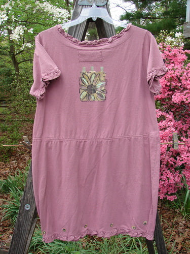 1991 Milkmaid Dress Daisy Dusty Pink OSFA on a clothes rack with a flower design, featuring a unique bell-shaped lower hip and curly neck hem.
