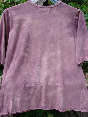 Barclay NWT Cotton Lycra Horizon Tee in Mottled Pinkberry, featuring a three-quarter sleeve design with a flattened neckline and curly edges, hanging outdoors on a plastic hanger.