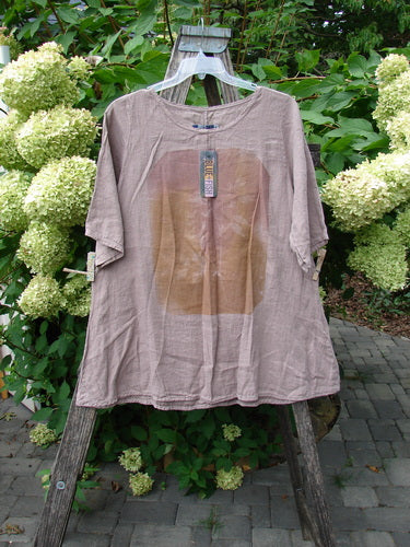 Barclay NWT Linen Lucida Top Moon Fern Oriel Size 0 displayed on a wooden trellis, showcasing its flowy A-line shape and rounded neckline, with hydrangeas providing a natural backdrop.