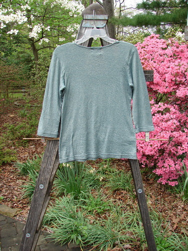 2000 Litmus Squareneck Top Unpainted Puddle Size 1 displayed on a wooden rack, showcasing a slightly flared hem and wider squared neckline with neatly stitched accents.
