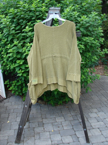 Barclay Patched Crepe Perennial Tunic Top Woods Olive Size 2 displayed on a rack, showcasing its textured cotton crepe fabric, front drop wrap side pockets, and varying dip hemline.