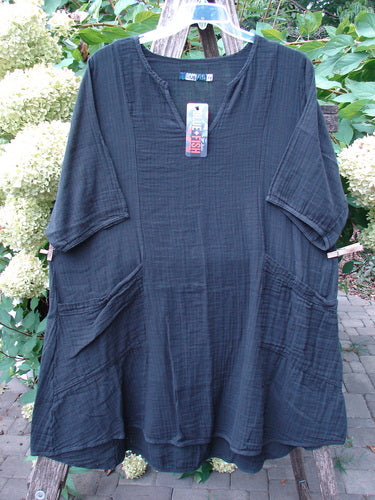 Barclay NWT Gauze Keyhole Bliss Pocket Dress Unpainted Black Size 0, featuring a crinkled texture, scooped neckline, and large front pockets, displayed on a hanger against a floral background.