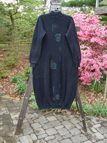 1996 Thermal Day Dress Abstract Black Size 0 displayed on a wooden stand, featuring ribbed cuffs, hemline, mock ribbed neck, and unique vertical seams with abstract paint accents.