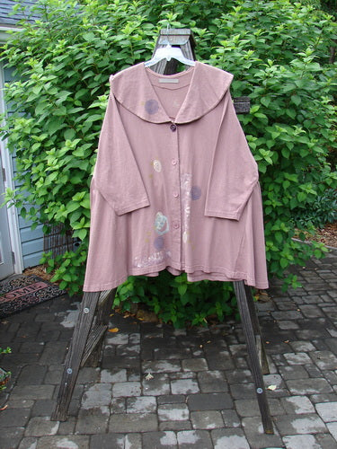 1994 Wanderer's Jacket Mind Cliff Size 2: A pink jacket on a rack with a wide shawl collar, sectional side inserts, and a varying hemline. Bust 54, Waist 70, Hips 90.