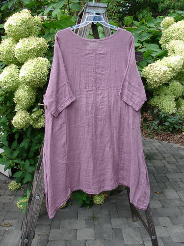 Barclay NWT Linen Wave Pocket Dress in Dried Floral Tulsi Rose Size 0, hanging on a ladder, features a seamless bodice, elbow-length pinched sleeves, and front top entry drop pockets.