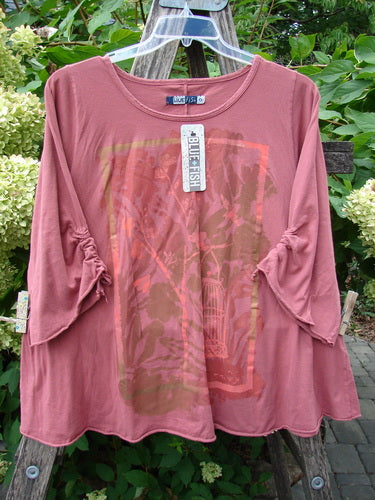 Barclay NWT Draw Gather Sleeve Cafe Top Free Bird Desert Size 0 displayed on a wooden ladder, showcasing its slightly flared sleeves, ruched detailing, square graphic, and swing tag, epitomizing Blue Fish's creative vintage style.