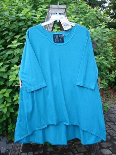 Barclay NWT High Low Top Unpainted Pacific Aqua Size 2 displayed on a hanger, showcasing its feminine neckline, varying hemline, three-quarter sleeves, and A-line shape.