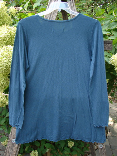Barclay NWT Modal Slub Long Sleeved Simple Tee Unpainted Morocco Size 0, back view, features a lightweight knit with long narrow sleeves, A-line shape, hip flare, and raw edges, hanging outdoors.