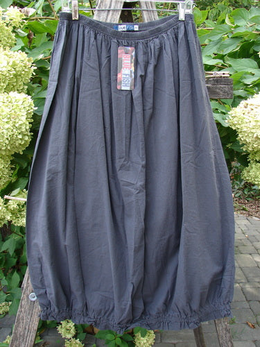 Barclay NWT Batiste Airy Lawn Skirt Unpainted Black Sand Size 0 features a balloon silhouette with an elasticized waistband, displayed on a wooden ladder against a lush outdoor backdrop.