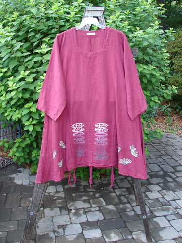 Barclay Linen Venetian High Vent Tunic Dress Cornflower Berry Size 2 displayed on a rack, showcasing its flowing A-line shape, softly squared neckline, and intricate S-shaped seams.