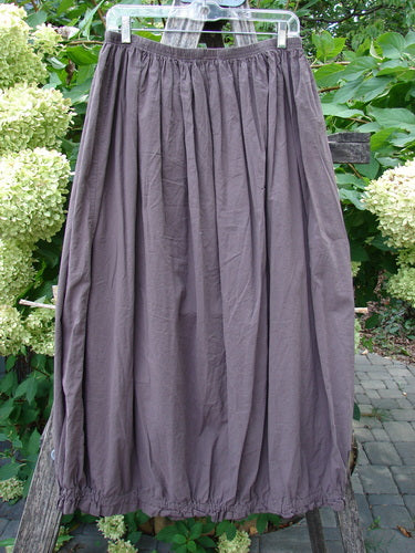 Barclay NWT Batiste Airy Lawn Skirt Unpainted Brown Sparrow Size 0, displayed on a hanger outdoors, showcases a flowing full-length design with a wide barrel shape and elastic waist and hem.