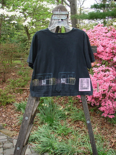 2000 Short Sleeved Crop Tee Transition Black Size 1 displayed on a wooden stand, featuring a wider, flat neckline and a boxy crop shape.