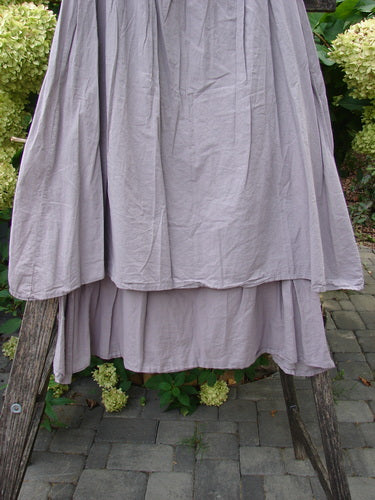 Barclay NWT Batiste Two Story Shaunting Skirt in Soft Mauve, displayed on a wooden frame outdoors, features a two-layered design with elastic waist, emphasizing Bluefishfinder.com's vintage, expressive style.