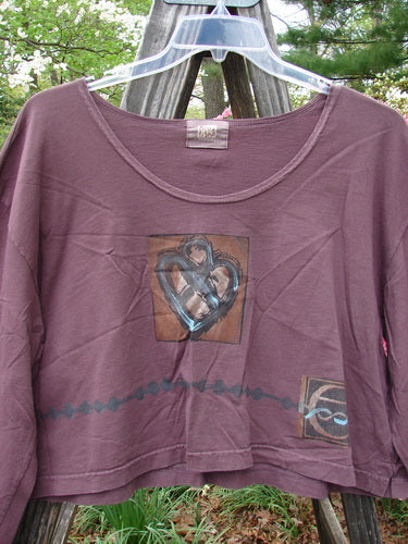 2000 Kell's Top Celtic E Loam Size 1, features a purple shirt with a heart design and short boxier shape, showcasing a bright Celtic letter E theme on organic cotton.