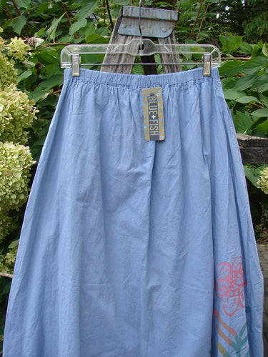 Barclay NWT Batiste Two Story Shaunting Skirt in pale sky-blue hangs outdoors, featuring an ankle-length, lightweight cotton design with a subtle floral motif and elastic waist, embodying Blue Fish's creative spirit.