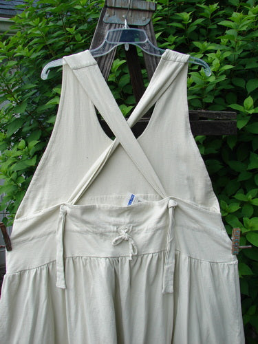 1999 NWT Tadpole Jumper Single Stripe Pike Natural OSFA displayed on a swing, highlighting its sweeping hemline, adjustable shoulder straps, and signature Blue Fish Patch, showcasing organic cotton fabric.