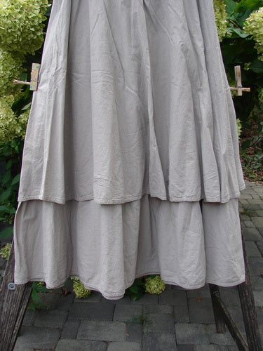 Barclay NWT Batiste Fold Over Stardust Tier Skirt Moon Rock Sand Size 0 displayed outdoors, showcasing its tiered, flowing design and forgiving waistline, hung against a natural backdrop on a wooden drying rack.