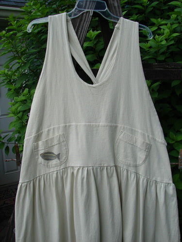 1999 NWT Tadpole Jumper Single Stripe Pike Natural OSFA hanging on a clothesline, showcasing its sweeping hemline, adjustable shoulder straps, crisscross back drawcord, and round-bottomed pockets.