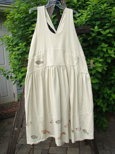 1999 NWT Tadpole Jumper Single Stripe Pike Natural OSFA displayed on a wooden ladder, showcasing adjustable shoulder straps, sweeping hemline, crisscross back, and signature Blue Fish patch.