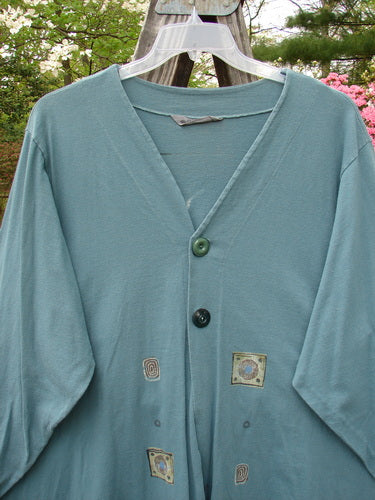 1997 Mask Jacket Quad Celtic Knot Cypress Size 2 displayed on a clothes rack, showcasing its bell shape, two-side pockets, and unique button closures.
