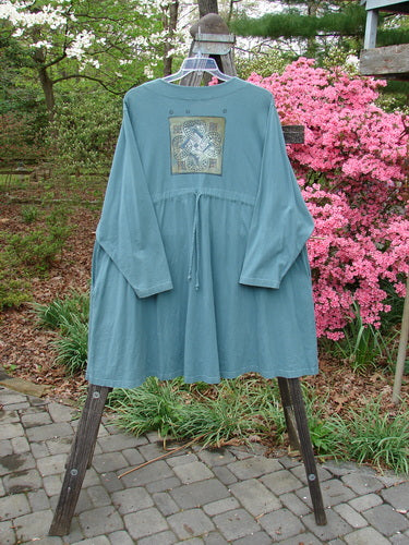 1997 Mask Jacket Quad Celtic Knot Cypress Size 2 displayed on a mannequin, showcasing the bell shape, two-button closure, deep side pockets, and rounded swing hemline.