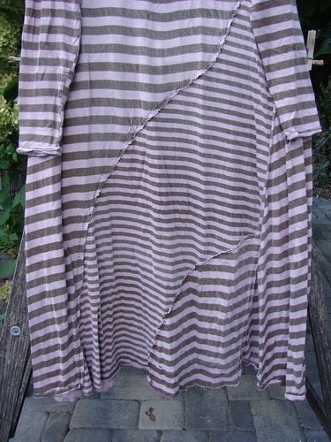 Magnolia Pearl Cotton Dylan Dress Hand Mended Lavender Stripe OSFA, featuring asymmetrical seams and curvy stitchery, drapes gracefully outdoors, showcasing its distinctive horizontal stripe pattern and unique hand-mended details.