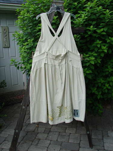 1999 NWT Tadpole Jumper Single Gold Fish Sky Natural OSFA displayed on a wooden rack, showcasing adjustable shoulder straps, sweeping hemline, and round-bottomed pockets with organic cotton fabric.