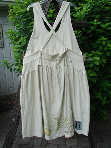 1999 NWT Tadpole Jumper Single Gold Fish Sky Natural OSFA displayed on a clothesline, showcasing adjustable shoulder straps, a sweeping hemline, crisscross back, round bottom pockets, and blue fish patch.