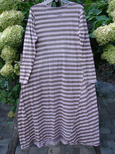 Magnolia Pearl Cotton Dylan Dress Hand Mended Lavender Stripe OSFA, featuring a loose fit with horizontal muted stripes, rounded neckline, tighter sleeves, and unique hand-stitched detailing, displayed outdoors.