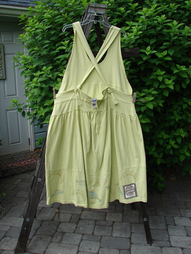 1999 NWT Tadpole Jumper Single Bass Moon Natural Citron OSFA, displayed hanging on a clothesline, showcasing its sweeping hemline, adjustable shoulder straps, and criss-cross drawcord back.