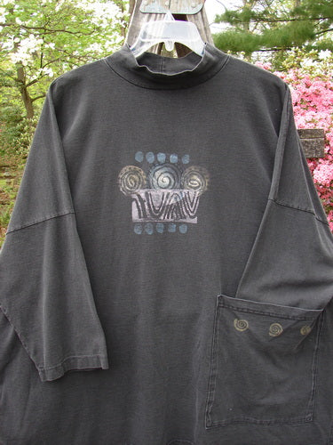 1996 Message Top Turn Path Black Size 3, featuring long sleeves, ribbed mock turtleneck, abstract paint design, oversized front pocket, in-seam side pocket, and varying hemline. Made from organic cotton.