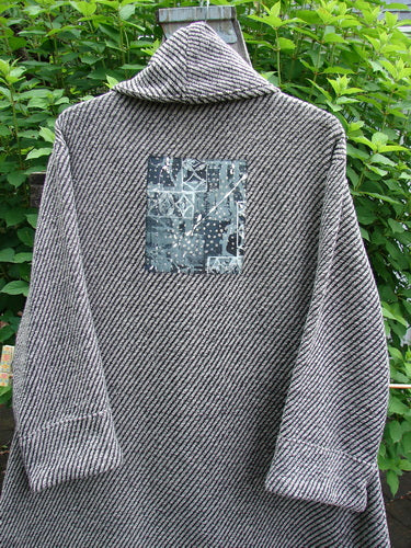 Barclay Patched Wool City Side Big Pocket Coat in Black White Stripe features a stand-up collar, triple button closure, deep front pockets, and an A-line flair with a unique upward scooped hemline.