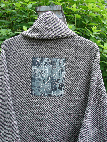 Barclay Patched Wool City Side Big Pocket Coat in Black White Stripe features a stand-up collar, triple button closure, A-line flair, deep front pockets, and unique varying hemlines, exemplifying Bluefishfinder.com's vintage style.