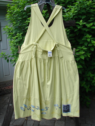 1999 NWT Tadpole Jumper Single Stripe Pike School Citron OSFA hanging on a clothesline, showcasing adjustable shoulder straps, sweeping hemline, crisscross back, and round-bottomed pockets.