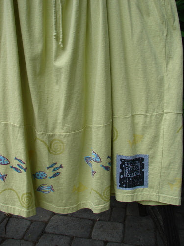 Close-up of 1999 NWT Tadpole Jumper Single Stripe Pike School Citron OSFA, featuring adjustable shoulder straps, a sweeping hemline, criss-cross back, horizontal seam, and round-bottomed pockets.