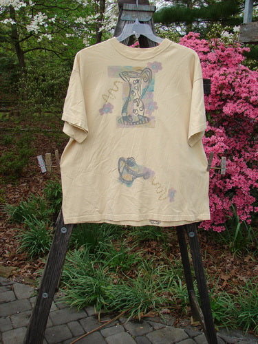 1995 Short Sleeved Tee Garden Water Glint Size 1, displayed on a rack, features a thick ribbed neckline, drop shoulders, and a garden water-themed design in superior detail.