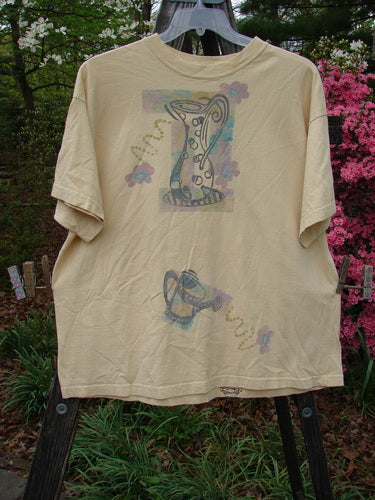1995 Short Sleeved Tee Garden Water Glint Size 1 displayed on a hanger, showcasing a detailed garden water theme painting, thicker ribbed neckline, and drop shoulders from the Spring Collection.